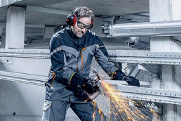 Arbeiter mit vor Funken schützender uvex metall Schutzausrüstung beim Metallschleifen