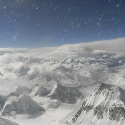 Blick vom Mount Everest über die schneebedeckten Ausläufer tief unten