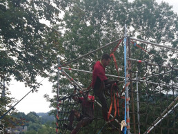 Teilnehmer am Wildsau Dirt Run mit sicherem Halt am Klettergerüst dank rutschfester uvex Schutzhandschuhe