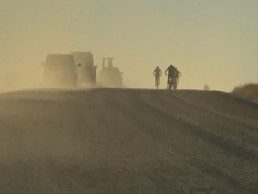 Mountainbiker fahren durch aufgewirbelten, staubigen Sand in der Wüste Namibias