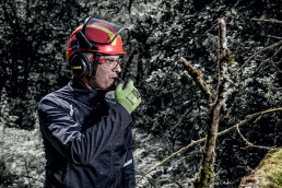 Forstarbeiter mit uvex pheos forestry Schutzhelm inklusive Visier und Kapselgehörschutz im Wald