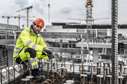 Bauarbeiter in gelber uvex suXXeed construction Warnkleidung mit Reflektorstreifen