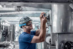 Schwarz-blaue uvex megasonic Schutzbrille mit Kopfband für Arbeiten in der Industrie