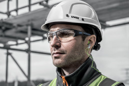 Bauarbeiter mit uvex Schutzbrille, Schutzhelm und Gehörschutzstöpseln