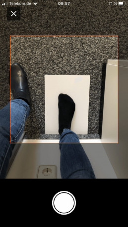 Fotofunktion in der uvex Größenberater-App zur Ermittlung der Schuhgröße anhand des Größenverhältnisses vom Fuß zu einem Blatt Papier