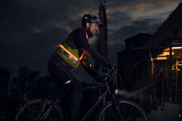 Radfahrer mit uvex protection active flash selbstleuchtender Warnweste für mehr Sichtbarkeit im Dunkeln