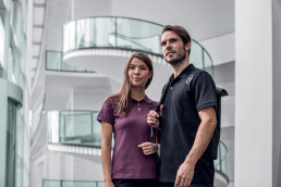 Frau und Mann in nachhaltigen und hautfreundlichen Poloshirts aus der uvex 26 Kollektion