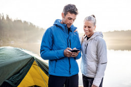 Mann und Frau in wärmenden und isolierenden Outdoorjacken aus der uvex alldayactive Kollektion