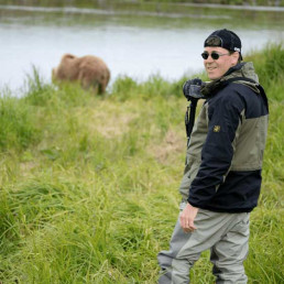 Fotograf mit uvex Schirmkappe fotografiert einen Bären in Alaska