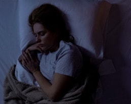 Frau schläft nachts in ihrem Bett.