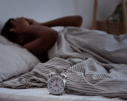 Frau liegt um 4 Uhr nachts schlaflos im Bett.