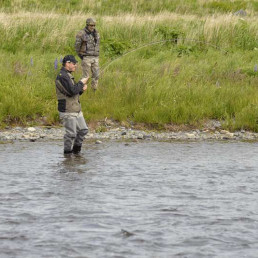 Männer in uvex Schutzausrüstung beim Fliegenfischen an einem Gewässer in Alaska