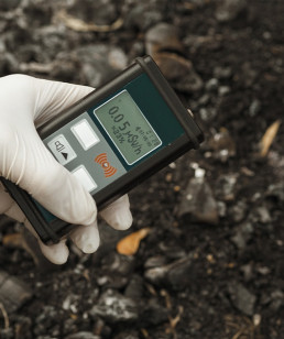 Person hält Dosimeter zur Messung radioaktiver Strahlendosis in der Hand.