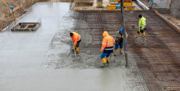 Bauarbeiter in wärmender und vor Nässe schützender Arbeitsschutzkleidung auf einer winterlichen Baustelle