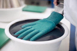 Application d'enduction dans l'usine de gants de protection uvex à Lunebourg, en Allemagne